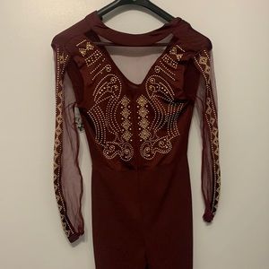 This Burgundy jumpsuit is from rainbow and has gold rhinestones.